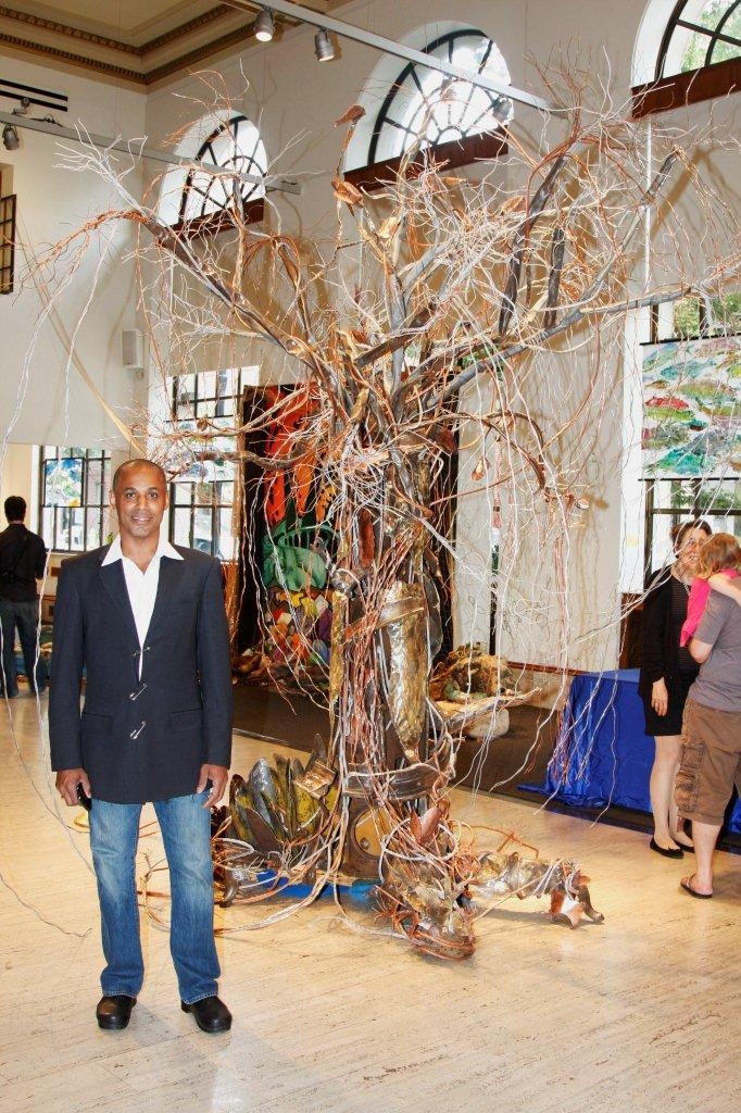 Wilfredo Morel frente a una de sus esculturas
