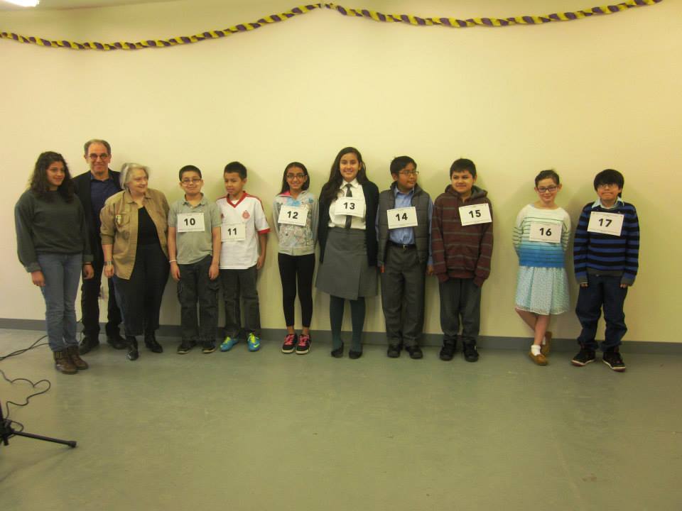 El jurado del Primer concurso de deletreo en español de Poughkeepsie junto a ocho de los niños participantes.